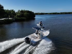 A speedboat navigates through serene waters surrounded by lush mangroves, showcasing an exciting day on the water.