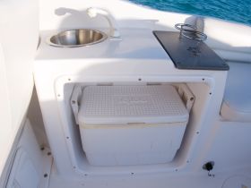 A well-equipped boat bar area featuring a cooler and sink, perfect for keeping drinks chilled while enjoying time on the water.