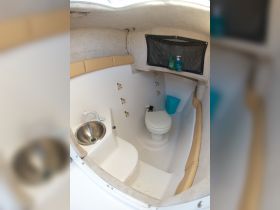 A clean and functional boat bathroom featuring a sink and toilet, ideal for comfort during trips at sea.
