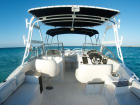 A clean and spacious interior view of a boat's helm and seating area, showcasing the modern design and amenities perfect for a day on the water.