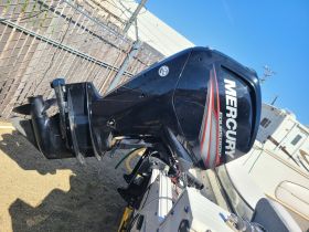 Close-up of a Mercury four-stroke outboard engine, showcasing its robust design and features, ideal for enhancing boating performance.