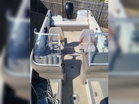 An overhead view of the interior of a boat showcasing the helm and seating area, perfect for comfortable cruising and fishing trips.
