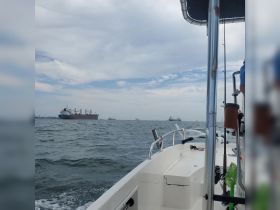 A scenic view from a boat showcasing multiple ships navigating through the ocean, perfect for maritime enthusiasts and those exploring coastal waters.