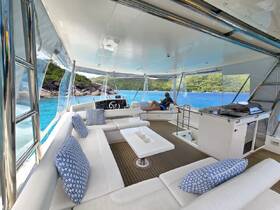 A cozy interior view of a boat featuring comfortable seating and a helm, perfect for relaxing while enjoying stunning turquoise waters.