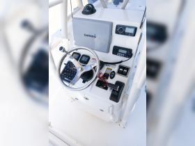 A detailed view of the helm and console of a boat, showcasing essential navigation equipment and controls for a smooth sailing experience.