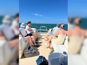 A group of friends relaxes on a boat, enjoying the sun and sea breeze — perfect for a day of fun on the water.