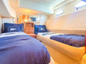 Cozy interior of a boat cabin featuring twin beds and stylish decor, perfect for relaxing during your maritime adventures.