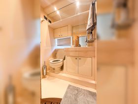 A clean and well-appointed bathroom inside a boat, featuring modern fixtures and ample storage — ideal for comfortable cruising.