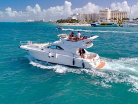 A lively group enjoys a day on a yacht cruising through vibrant turquoise waters, showcasing the perfect blend of relaxation and adventure.