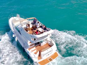 A lively group enjoys a day on a yacht, cruising through vibrant turquoise waters — perfect for unforgettable gatherings and celebrations on the sea.