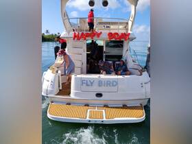A lively birthday celebration aboard the 'Fly Bird' yacht, featuring guests enjoying the festivities on the water.