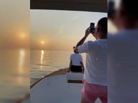 A couple captures a stunning sunset while enjoying a serene moment on a boat, perfect for romantic outings and memorable experiences on the water.