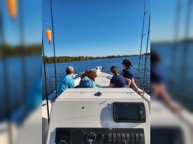 A group of friends enjoys a day on the water, taking in the scenery while aboard a fishing boat — perfect for a relaxing outing or fishing adventure.