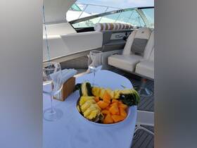 A beautifully arranged platter of fresh pineapple and melon sits on a table aboard a luxury boat, perfect for enjoying refreshments while cruising on the water.