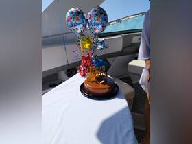 A festive birthday setup featuring a delicious cake and colorful balloons aboard a boat, perfect for celebrating special occasions on the water.
