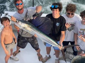 A group of excited boys celebrates their impressive catch while fishing, showcasing the thrill of a successful day on the water.