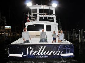 A lively group enjoys their time aboard the Stelluna in Destin, Florida, showcasing the fun and camaraderie of a night on the water.
