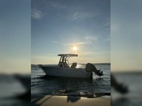 A stunning side view of a speedboat silhouetted against a vibrant sunset, showcasing the vessel's sleek design as it rests on the water.