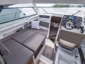 A stylish interior view of a boat's cabin featuring comfortable seating and a well-equipped helm, perfect for relaxing and navigating on the water.