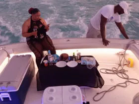 A cozy setup on a boat featuring a table with food and drinks, perfect for enjoying a delightful meal while cruising on the water.