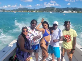 A lively group poses for a fun photo on a boat, enjoying the sun and water — perfect for memorable outings and celebrations.