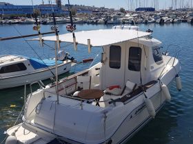 A well-equipped boat docked in a marina, showcasing its sleek design and fishing gear, perfect for a day on the water.