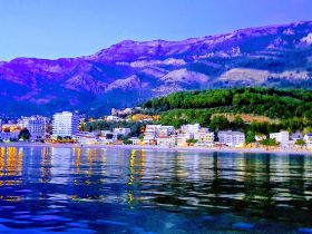 A stunning view of a coastal town illuminated at dusk, reflecting beautifully on the calm waters — perfect for capturing the essence of serene evening boat trips.
