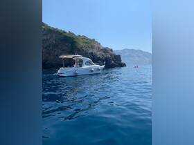 A serene view of a boat anchored near a rocky coastline, showcasing the tranquil waters and beautiful landscape — perfect for exploring coastal destinations.