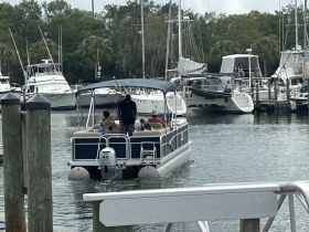 A family enjoys a day out on a pontoon boat at the marina, showcasing the perfect setting for fun and relaxation on the water.