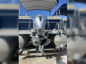 A clear view of the back of a pontoon boat showcasing its motor and structure, ideal for understanding the vessel's design and features.