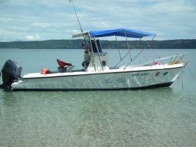 A clear view of the 'La Pola' boat docked in shallow waters, showcasing its sleek design and tranquil surroundings.