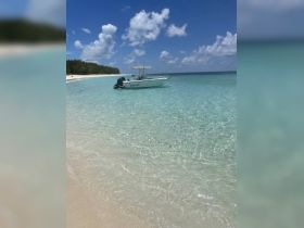 A serene view of a speedboat anchored in crystal-clear turquoise waters, perfect for exploring the beautiful coastline.