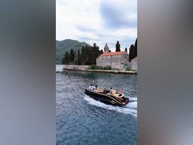 A couple enjoys a scenic boat ride past historic architecture and lush mountains, capturing the essence of adventure on the water.