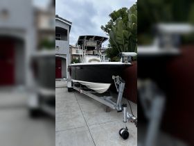 A sleek speedboat is docked in front of a residential property, showcasing its modern design and ready for the next adventure on the water.