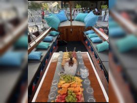 A beautifully arranged fruit platter and drinks set up on a boat, perfect for enjoying a refreshing day on the water with friends or family.