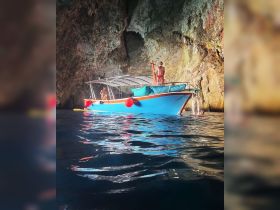 Guests enjoy an adventurous boat experience inside a stunning cave, showcasing the beauty of nature and water activities.