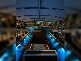 A cozy interior view of a boat's lounge area, featuring illuminated seating and a welcoming atmosphere, perfect for evening gatherings on the water.