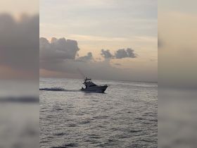 A sleek speedboat navigates the calm waters at sunset, showcasing the beauty of a serene evening on the ocean.