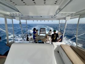 A group of friends enjoys a fishing trip on a boat, with the ocean stretching out behind them — perfect for adventure seekers and fishing enthusiasts.