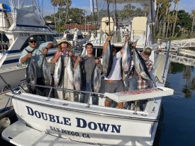 A group of anglers proudly displays their impressive catch aboard the 'Double Down' in San Diego, showcasing a successful fishing trip filled with camaraderie and excitement.