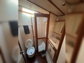 Interior view of a boat bathroom featuring a shower, toilet, and sink — showcasing the essential amenities for comfort on the water.