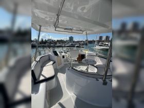 A spacious interior view of a boat's helm and seating area, showcasing modern design and comfort for an enjoyable boating experience.
