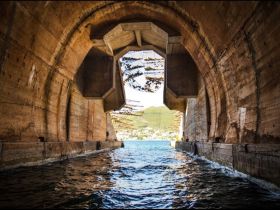 An abstract view of a structure with water, possibly a dock or harbor entrance, showcasing unique architectural features.