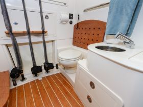 A clean and functional interior view of a boat's bathroom, featuring modern amenities and stylish wood accents, perfect for comfortable cruising.