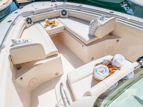A stylish interior view of a boat's lounge area featuring comfortable seating and refreshments, perfect for relaxing on the water.