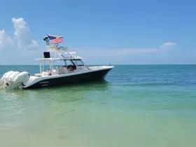 A sleek speedboat, the 'Everglades,' is docked in clear turquoise waters, showcasing a perfect day for boating adventures.