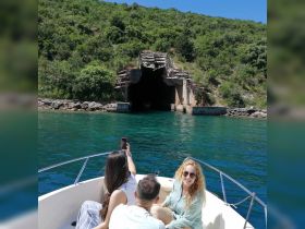 A group of friends captures a moment on their boat as they approach an intriguing tunnel, showcasing the thrill of adventure on the water.