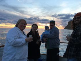 A joyful family gathers on a boat at sunset, enjoying drinks and creating cherished memories together — perfect for family outings and celebrations on the water.