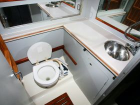 Interior view of a boat bathroom featuring a toilet and sink, showcasing the essential amenities for comfort on the water.