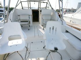 Interior view of a boat's helm area featuring white seating and a spacious layout, ideal for comfortable cruising.